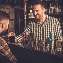 man-chatting-with-a-bartender-in-a-pub.jpg